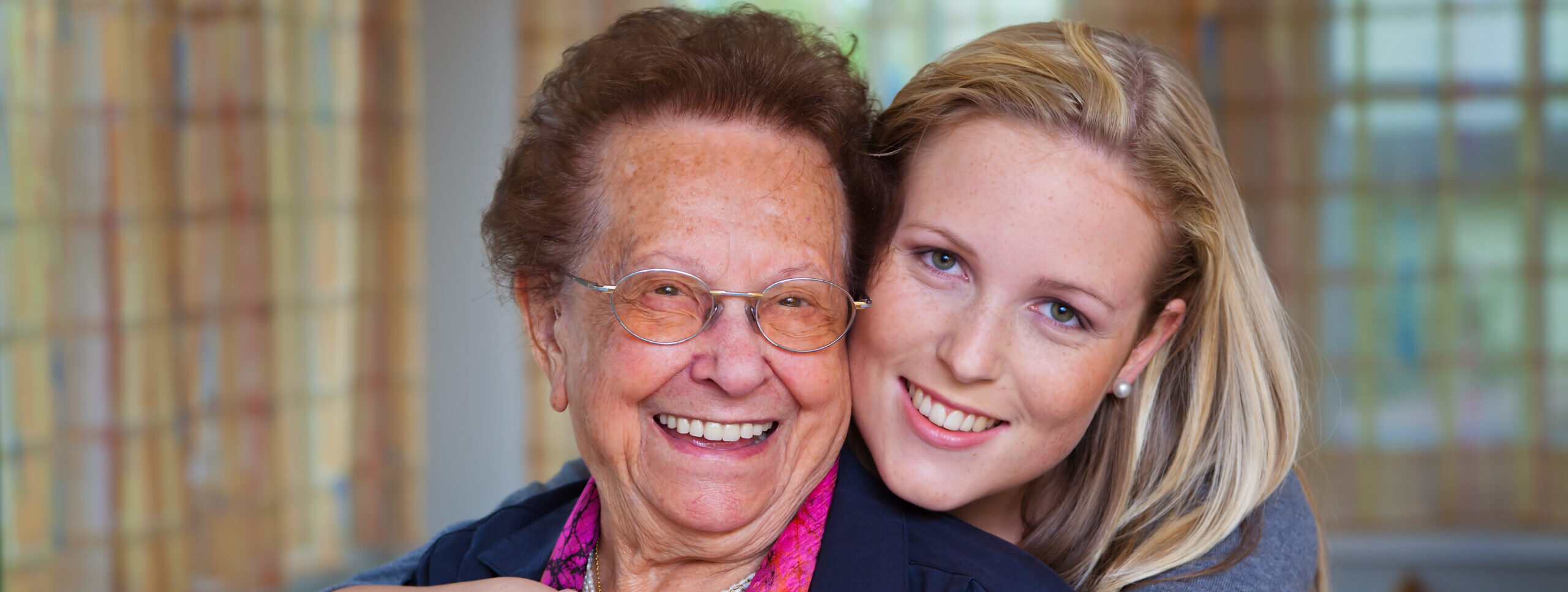 Grossmutter und Enkelin lächeln nach einem Besuch bei der Prophylaxe von SmileProfessionals!